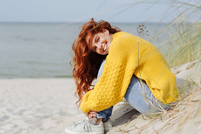 Frau sitzt am Strand